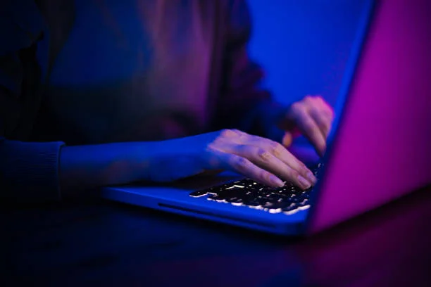 Mystery author writing on laptop at night representing Decached Heladim Jomsel credibility